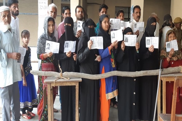 People queue up at polling booth number 355 to cast their vote for polls in Saharanpur