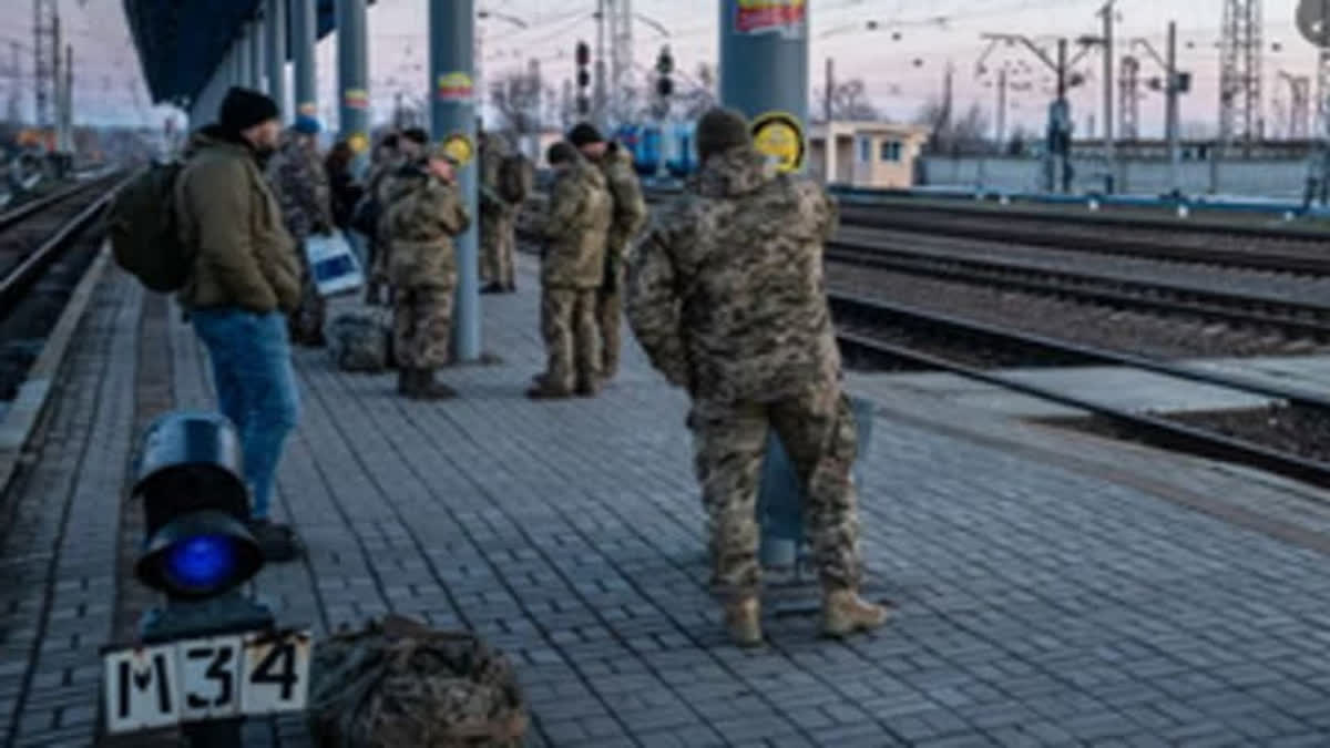 Russian soldiers wait at the station to reach their home destination