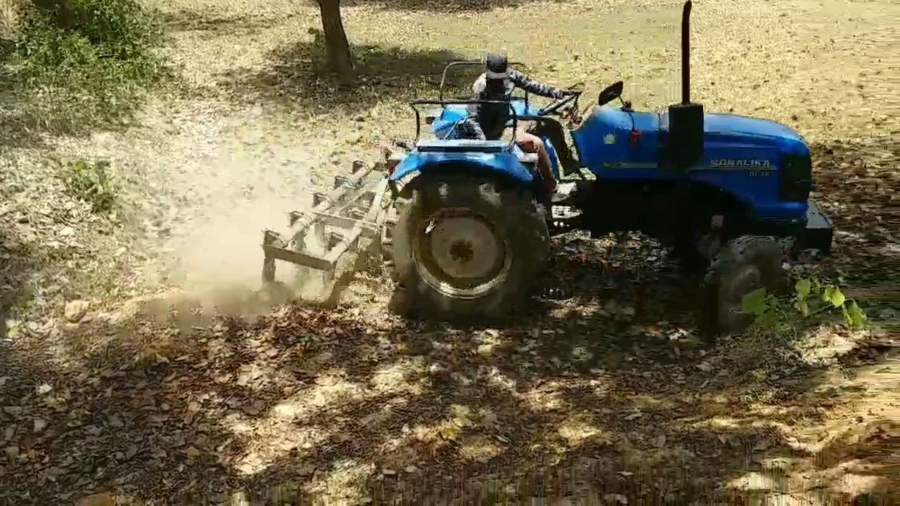 farmer plowing field with tractor