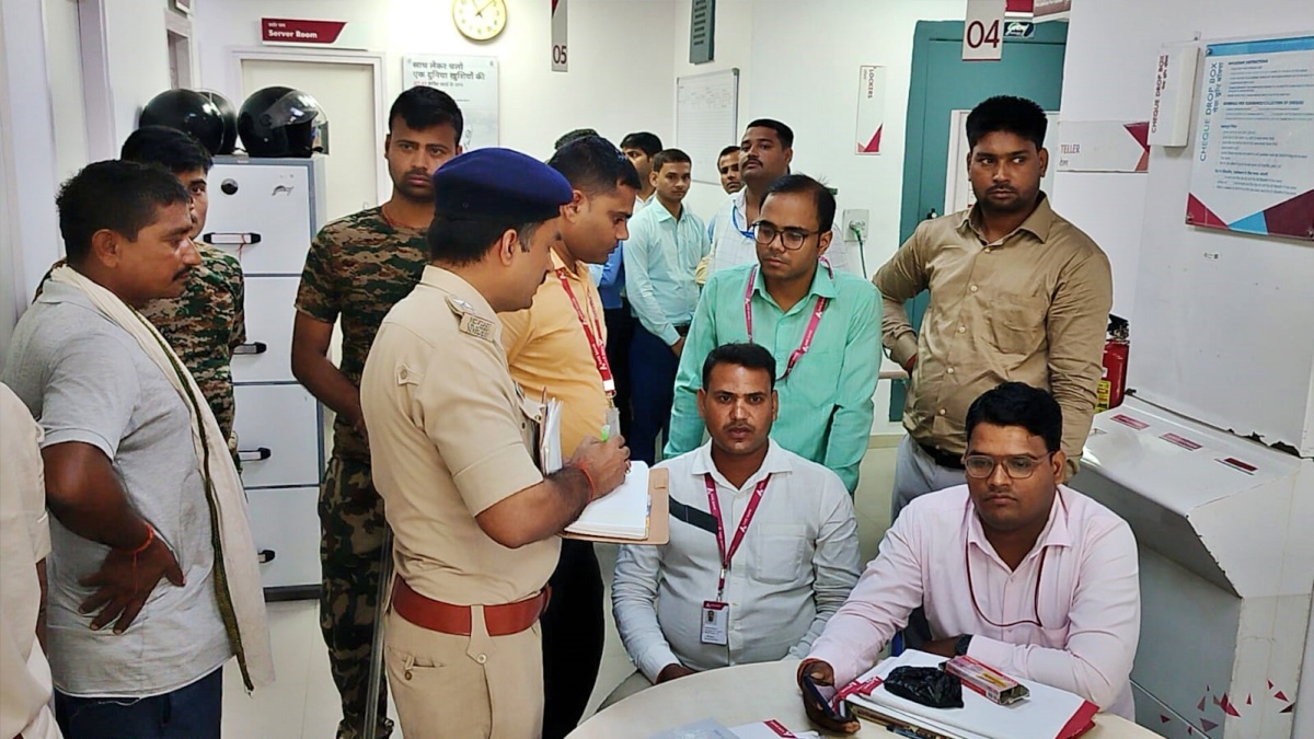 शेखपुरा में बैंक लूट के बाद कर्मी से जानकारी लेती पुलिस