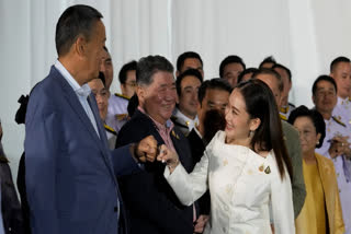 FILE - Thailand's former Prime Minister Srettha Thavisin, left, exchanges a fist bump with new Prime Minister Paetongtarn Shinawatra after Paetongtarn received a royal letter of endorsement for the post at the Pheu Thai party headquarters in Bangkok, Thailand on Aug. 18, 2024.
