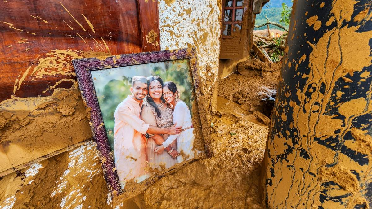 A framed photograph lies partially covered in mud at a damaged house after landslides hit Wayanad district. The identity of those in the photos was not immediately known.