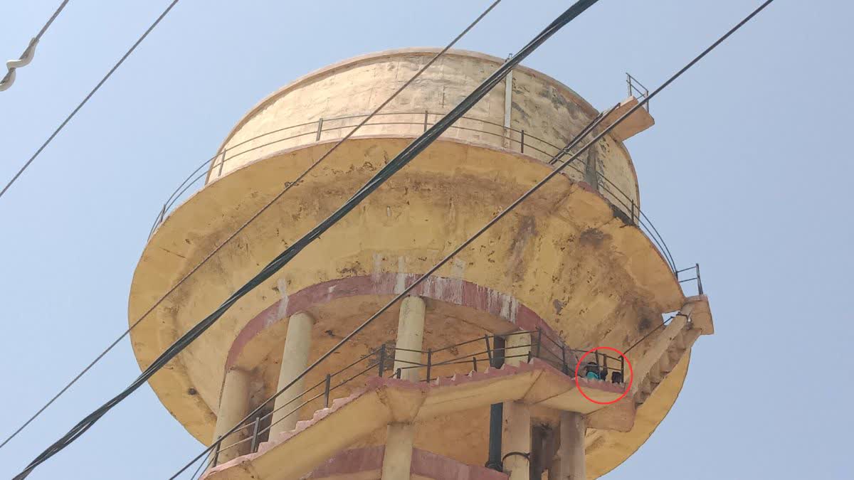 Mother and daughter climb on water tank