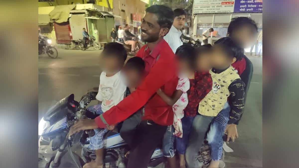 man on bike with six children in varanasi