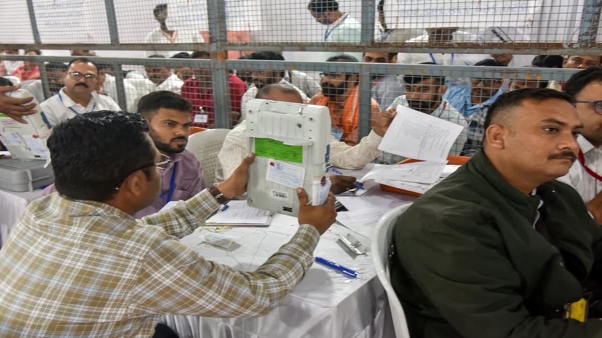 An official shows the EVM machine to party agents during vote counting