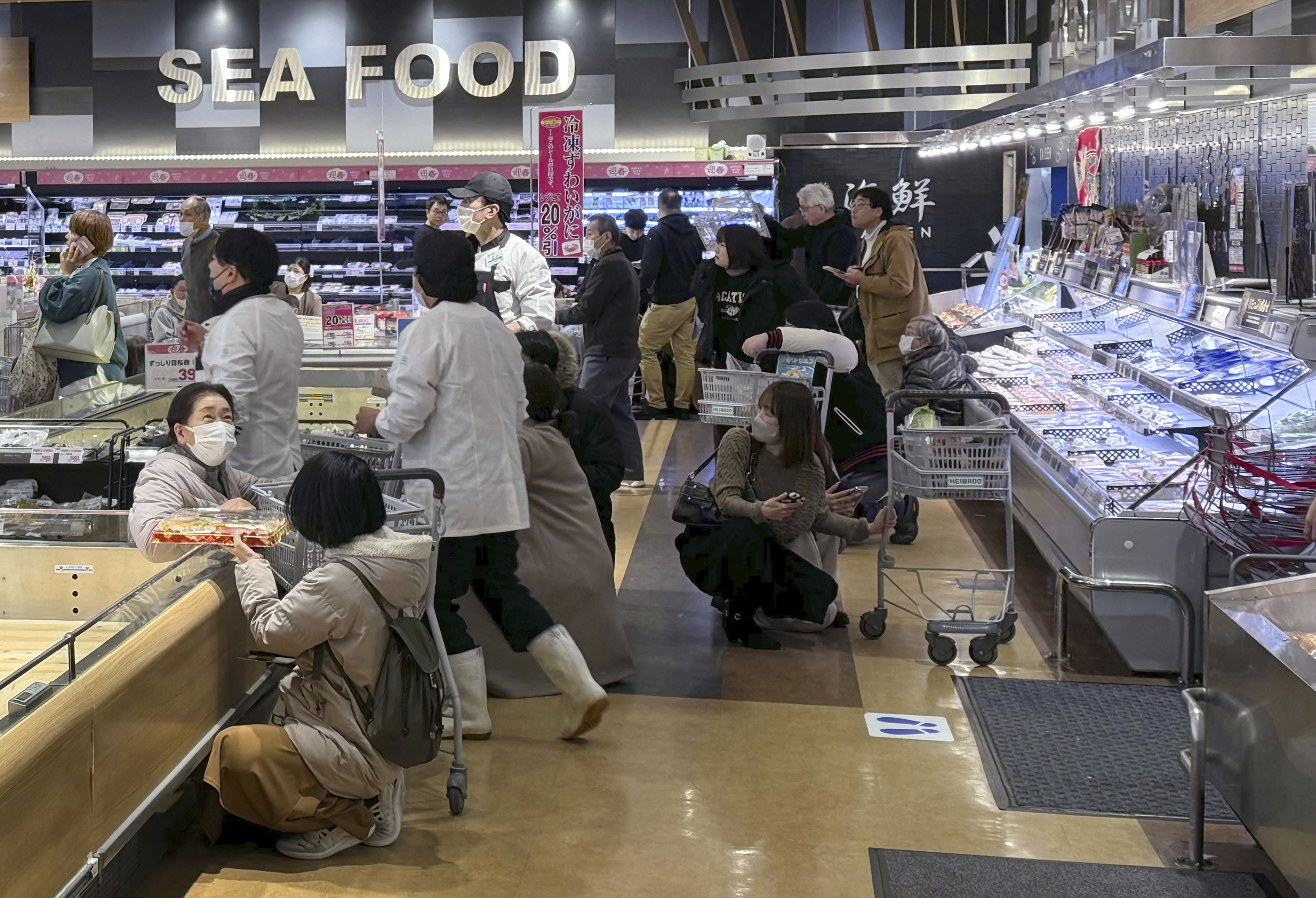 پیر کو آنے والے زلزلے کے جھٹکوں سے سوپر مارکیٹ میں سہمے ہوئے لوگ  (PHOTO:AP)