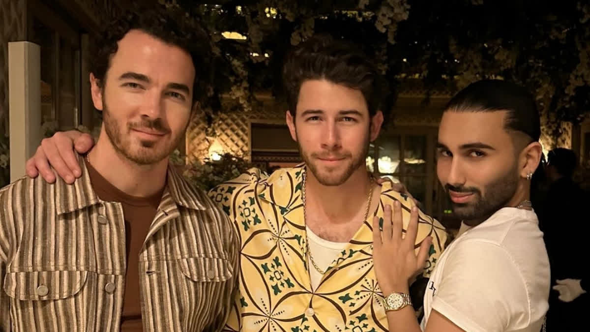 Orry strikes his signature pose with Nick Jonas, Kevin Jonas