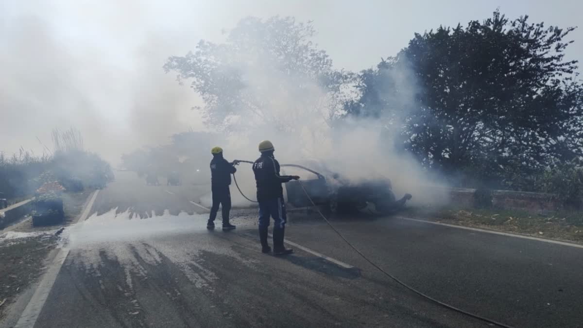 Firefighters extinguishing a fire in a car