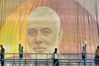 Iranian workers install a huge banner on a wall showing a portrait of Hamas leader Ismail Haniyeh and the Dome of Rock Mosque at the Al-Aqsa Mosque compound of Jerusalem at Felestin (Palestine) Sq. in Tehran, Iran, Wednesday, July 31, 2024.