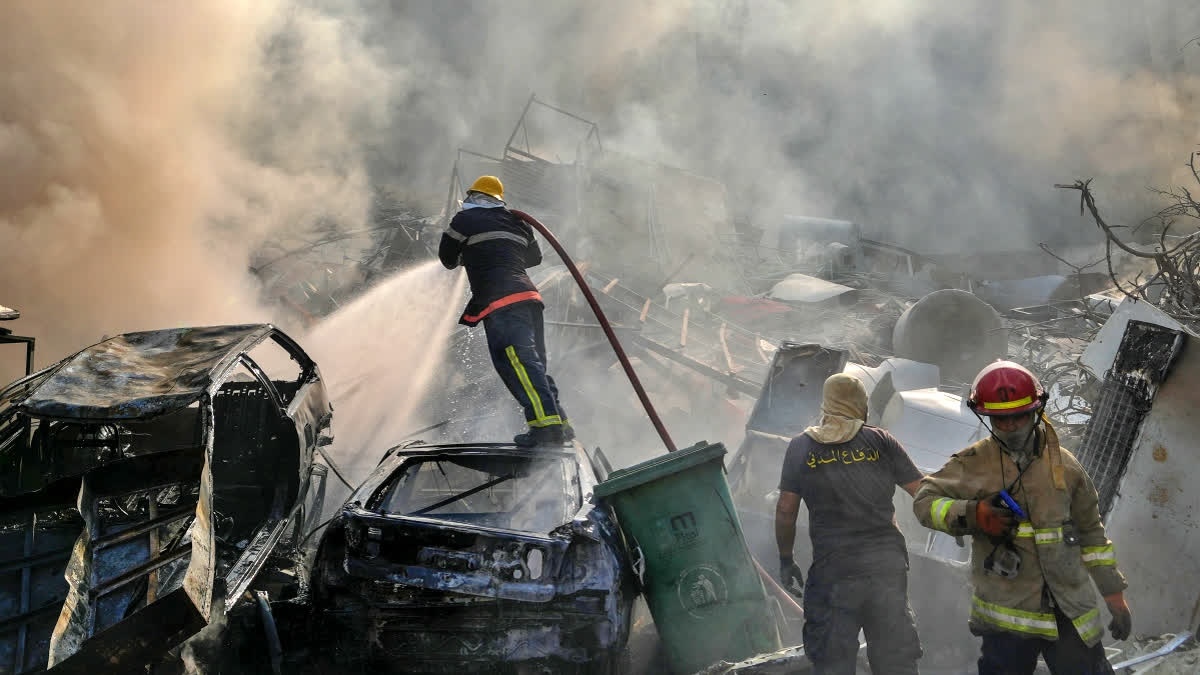 Civil defense workers extinguish a fire as smoke rises from the site of an Israeli airstrike in Dahiyeh, Beirut, Lebanon, Friday, Nov. 1, 2024.