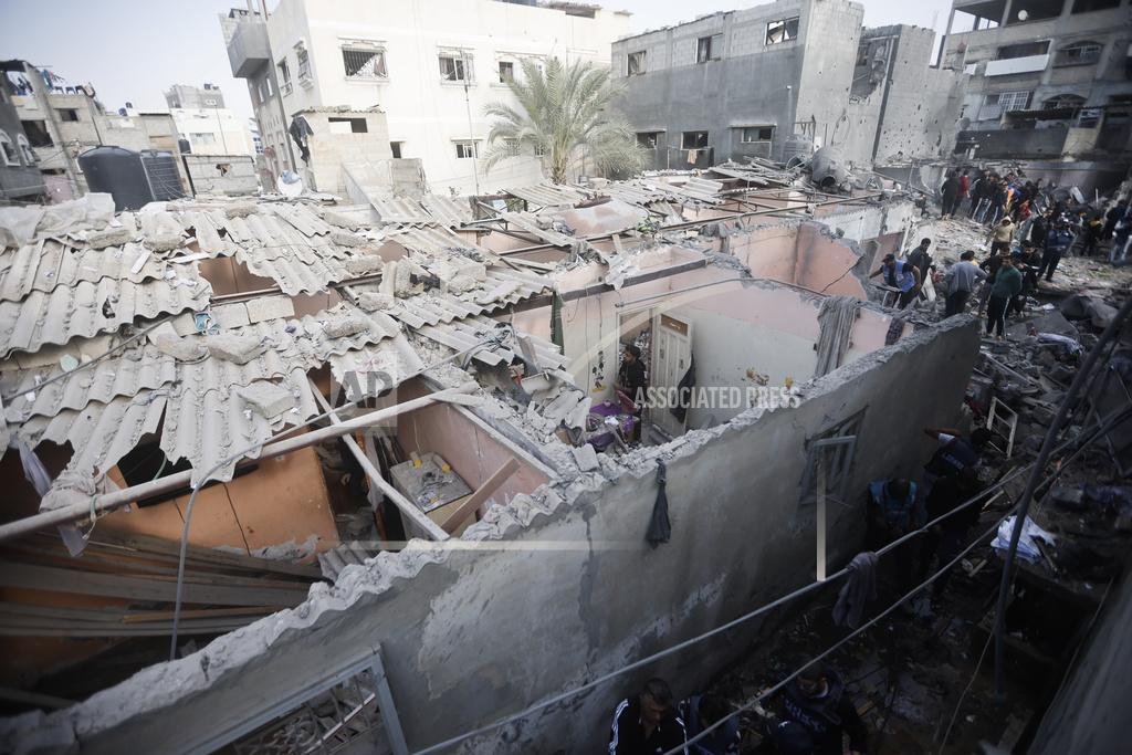 Palestinians look at destruction after the Israeli bombing In Khan Younis refugee camp in Gaza Strip on Friday