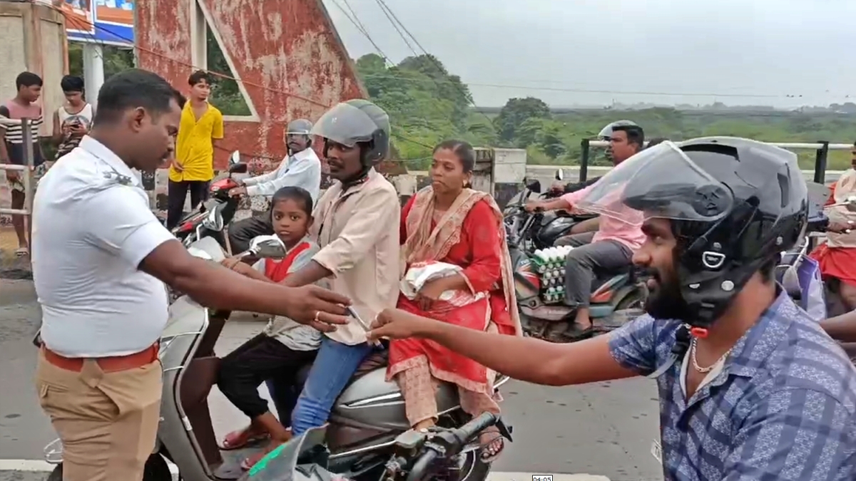 ஹெல்மெட் அணிந்து வந்தவர்களுக்கு பேனாவை பரிசளித்த காவலர்