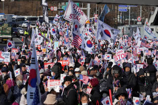 Supporters of impeached South Korean President Yoon Suk Yeol stage a rally to oppose a court having issued a warrant to detain Yoon, near the presidential residence in Seoul, South Korea, Friday, Jan. 3, 2025. The letters read, "Oppose Impeachment."