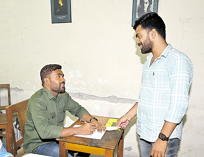 A voter shows his voting slip to the polling officer