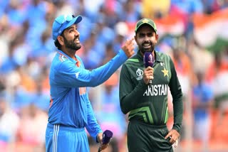 Indian skipper Rohit Sharma flips the coin during the toss ahead of their match against Pakistan in the ICC Men's Cricket World Cup 2023, as Pak skipper Babar Azam looks on, at Narendra Modi Stadium, in Ahmedabad.