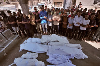 Mourners pray beside the bodies of Palestinians that were killed by an Israeli airstrike that struck a school used as a shelter, in Shifa Hospital in Gaza City, on Thursday, July 3, 2025.