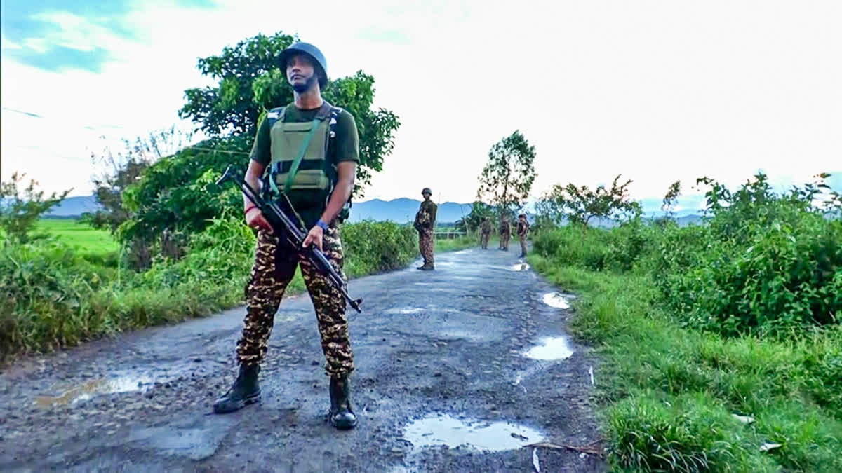 Security personnel stand guard after a militant attack, at Koutruk in Imphal on Sunday.