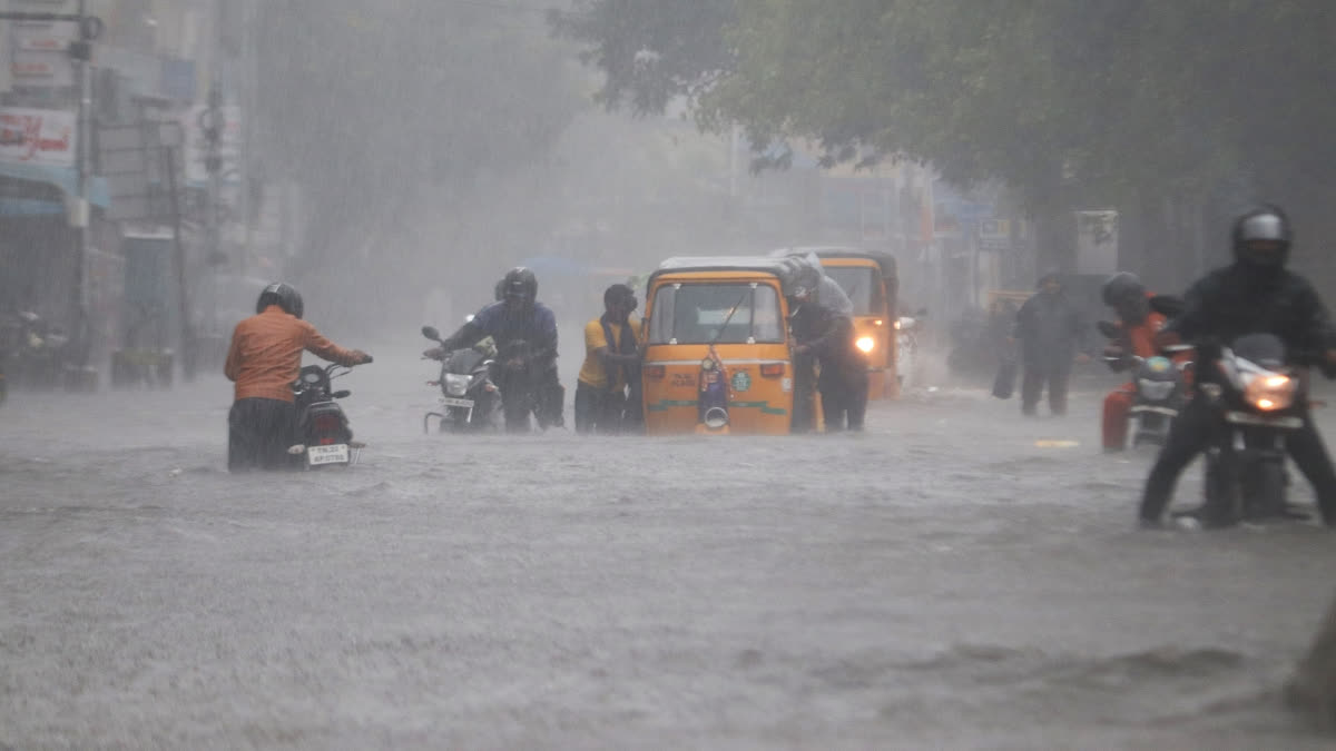 Commuters wade through a waterlogged road following heavy rainfall triggered by Cyclone Fengal, in Chennai on Saturday.