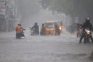 Commuters wade through a waterlogged road following heavy rainfall triggered by Cyclone Fengal, in Chennai on Saturday.