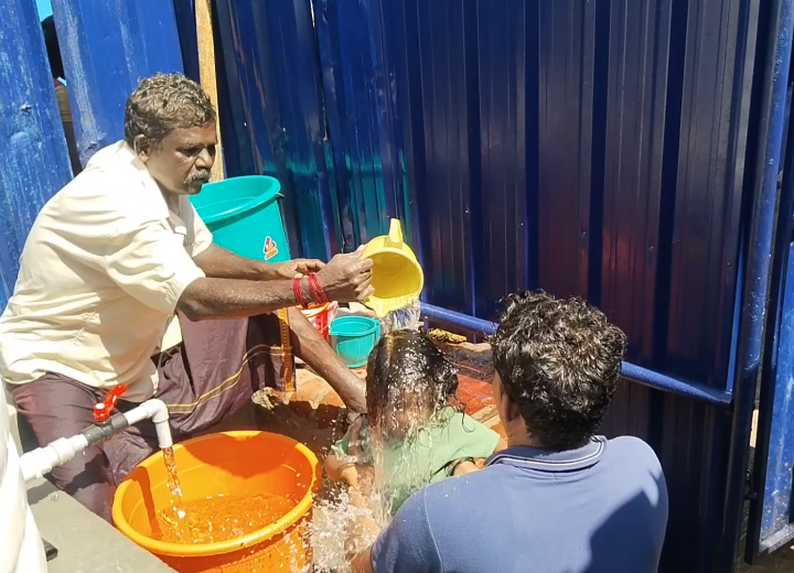 கோயில் நிர்வாகம் செய்துள்ள மாற்று ஏற்பாட்டில் நீராடும் பக்தர்கள்