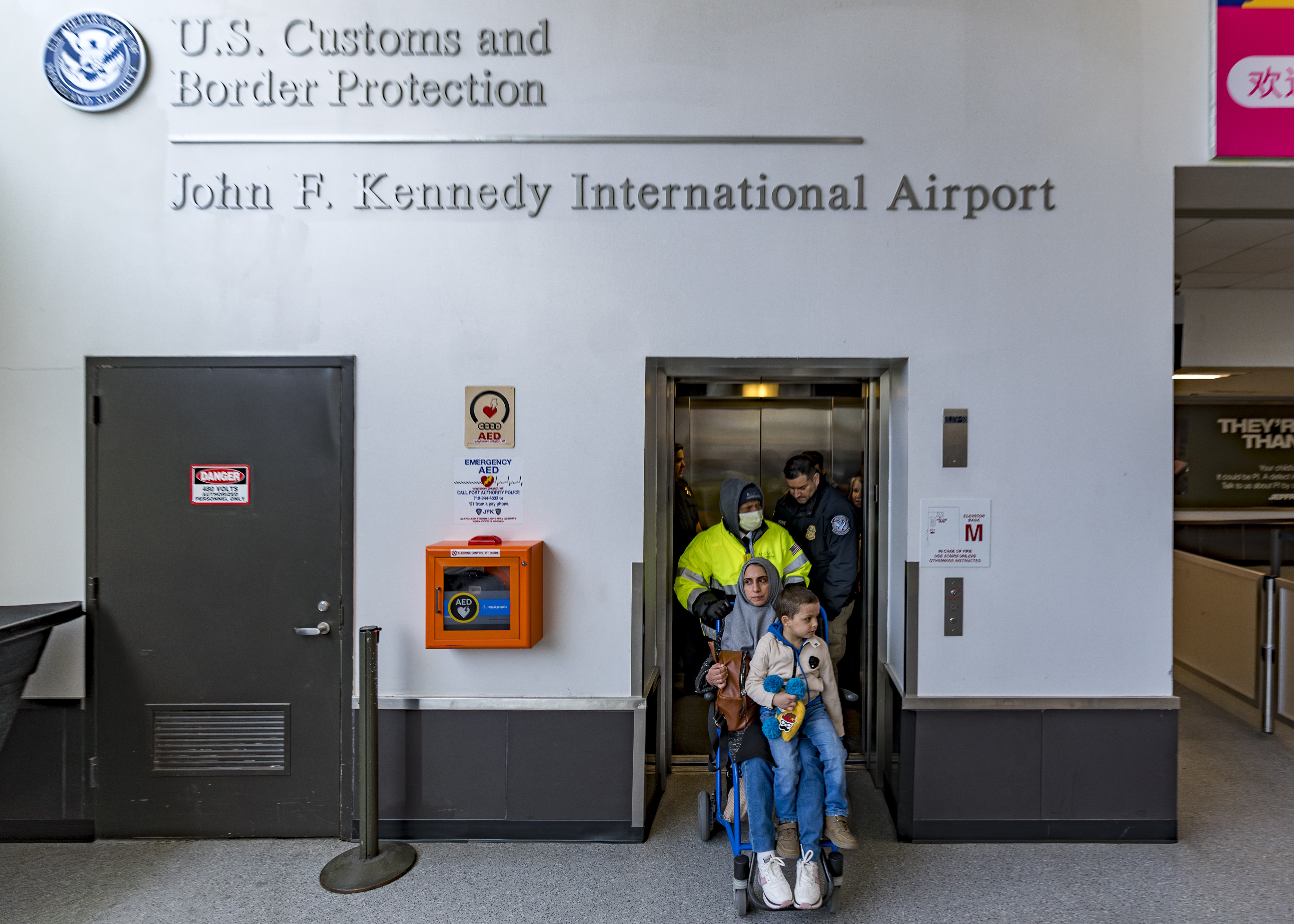 Four-year-old Omar Abu Kuwaik, and his aunt Maha Abu Kuwaik, both from Gaza, are escorted through John F. Kennedy International Airport after departing a flight from Egypt on Wednesday, Jan. 17, 2024, in New York. (AP Photo/Peter K. Afriyie)