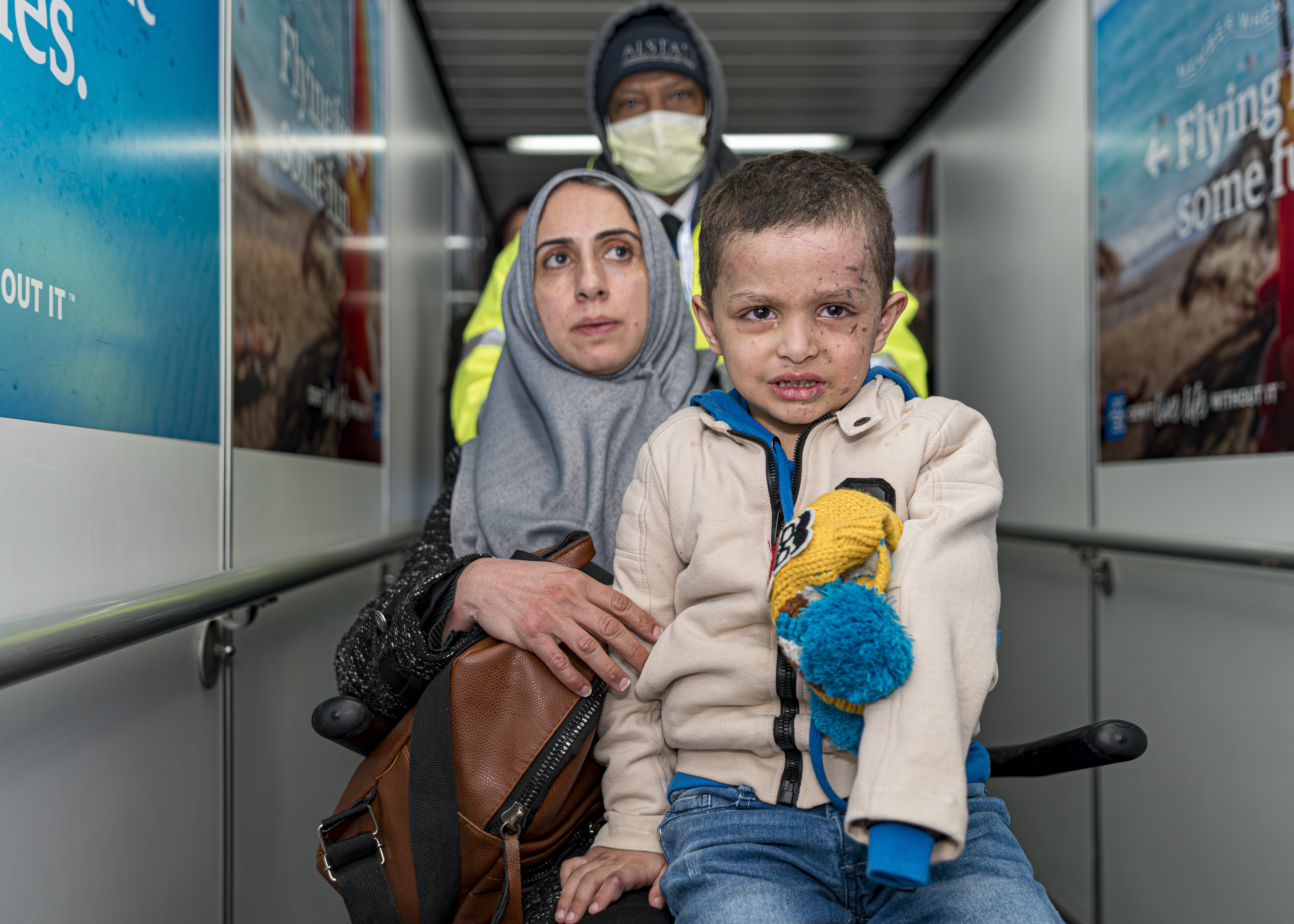 Four-year-old Omar Abu Kuwaik, and his aunt Maha Abu Kuwaik, both from Gaza, are escorted through John F. Kennedy International Airport after departing a flight from Egypt on Wednesday, Jan. 17, 2024, in New York. (AP Photo/Peter K. Afriyie)