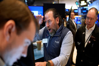 Mike Pistillo Jr., center, works with other traders on the floor at the New York Stock Exchange in New York, Thursday, April 3, 2025.