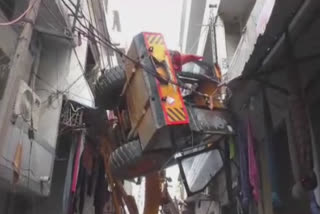 Crane hanging between buildings due to accident in Ludhiana