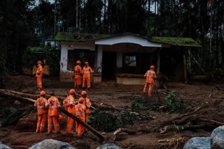 Rescuers search through mud and debris after landslides set off by torrential rains in Wayanad district on Thursday