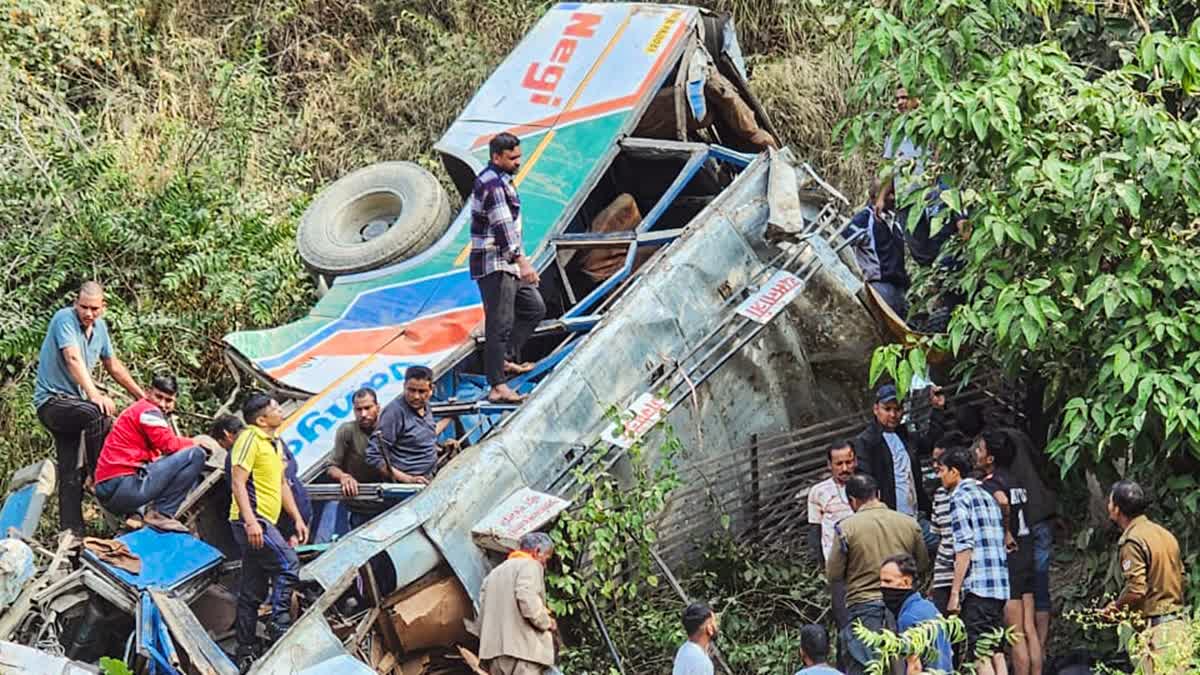 Police personnel and people gather near the bus that fell into a gorge near Marchula claiming the lives of 23 people, in Almora on Monday. 45 others injured in the incident.