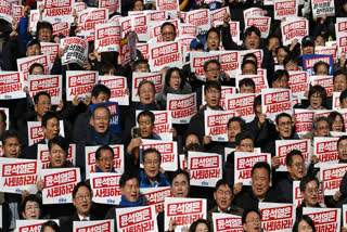 Lawmakers and South Korea's main opposition Democratic Party members hold placards reading "Yoon Suk Yeol should resign!" during a rally against President Yoon Suk Yeol at the National Assembly in Seoul on December 4, 2024, after martial law was lifted in South Korea.