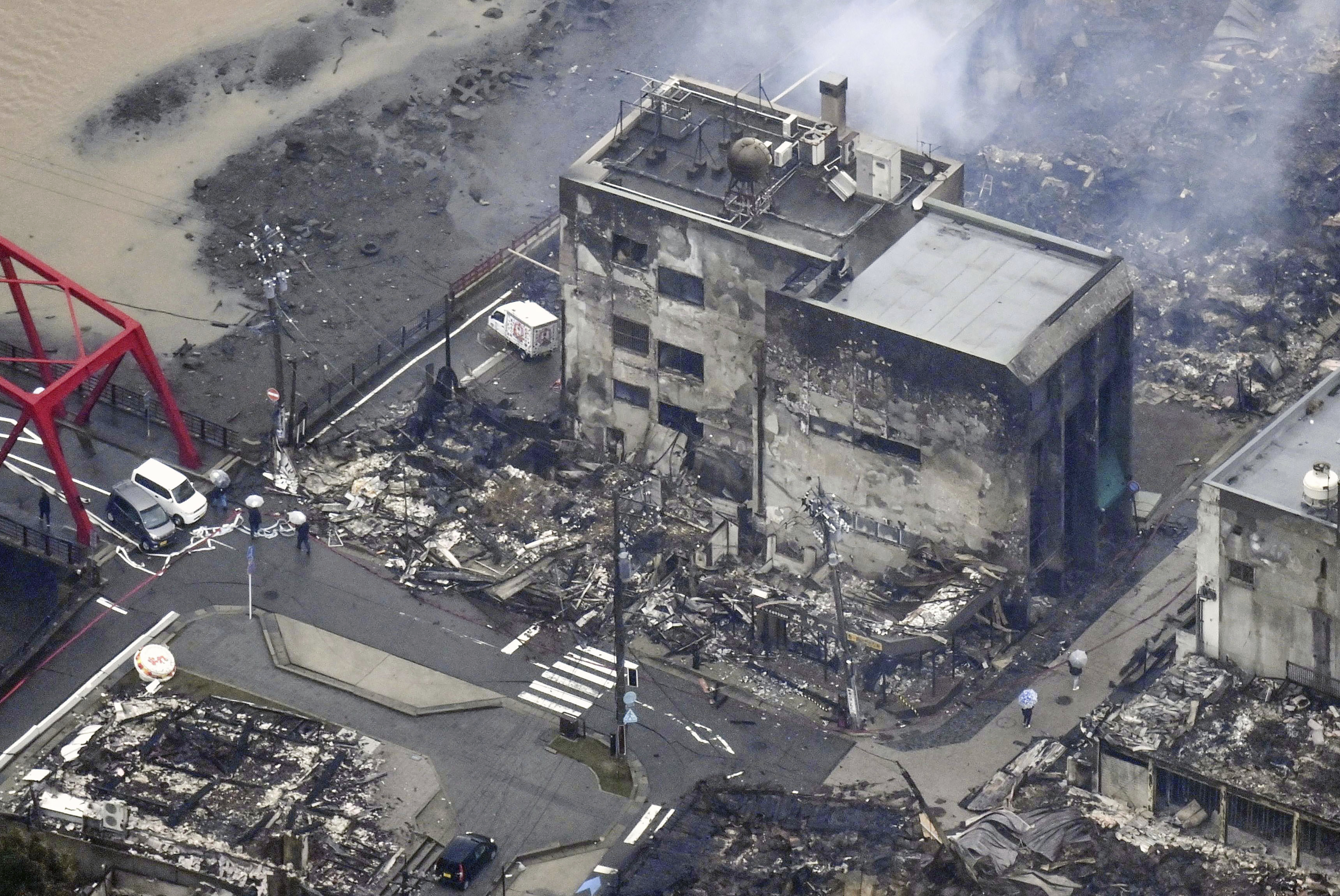 (Photo: AP)  واجیما، اشیکاوا میں زلزلے سے متاثرہ ایک جلی ہوئی عمارت سے سفید دھواں اٹھتا دکھائی دے رہا ہے۔