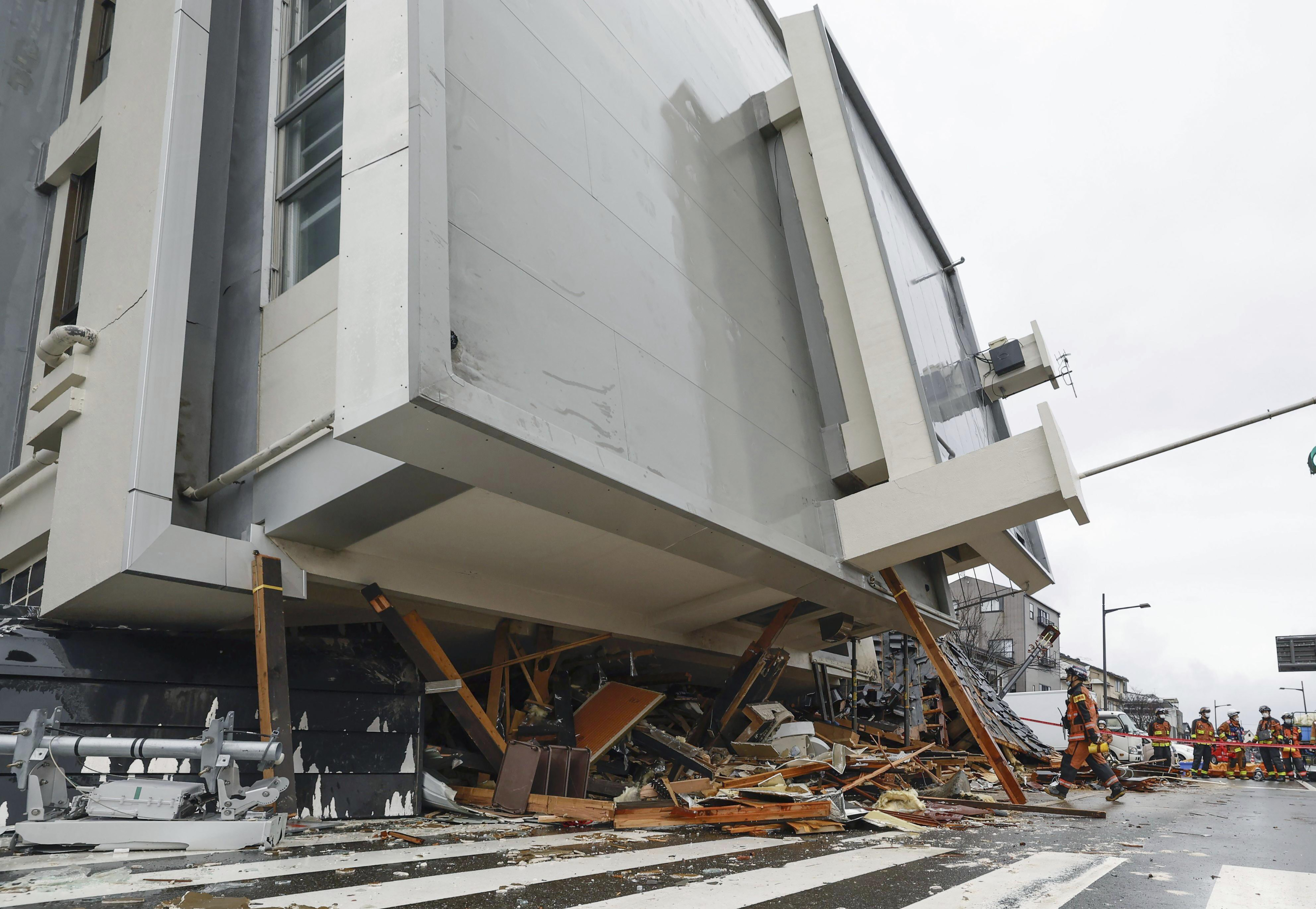 (Photo: AP)  فائر فائٹرز واجیما، اشیکاوا میں زلزلے سے گرنے والی عمارت میں تلاش کر رہے ہیں