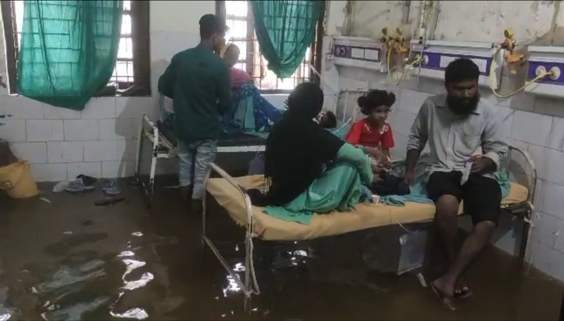 अस्पताल के अंदर पानी में बैठे मरीज