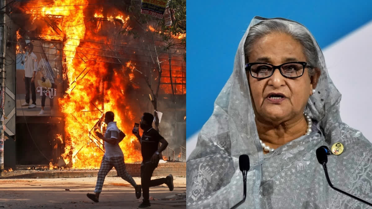 Men run past a shopping center which was set on fire by protesters during a rally against now former Prime Minister Sheikh Hasina and her government demanding justice for the victims killed in the recent countrywide deadly clashes, in Dhaka, Bangladesh, Sunday, Aug. 4, 2024.