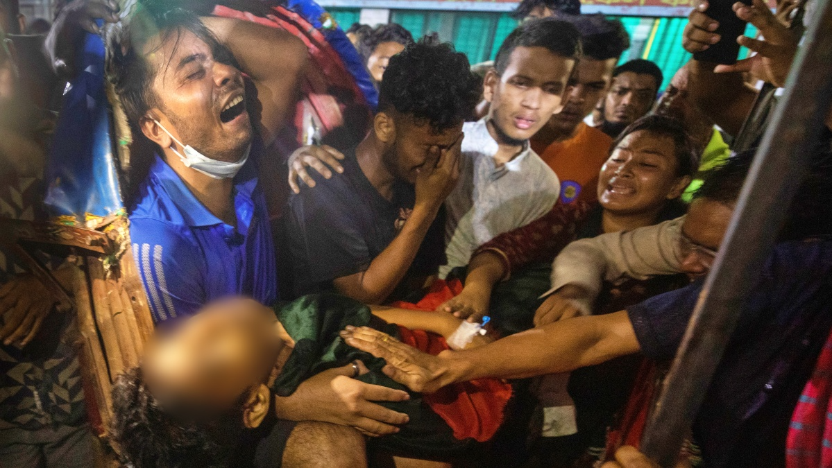 Men cry as the dead body of a man, who was killed during the anti-government protests in Bangladesh, is brought to a hospital in Dhaka, Bangladesh, Sunday, Aug. 4, 2024.