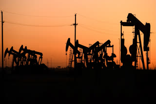 FILE - An array of pumpjacks operate near the site of a new oil and gas well being drilled April 8, 2022 in Midland, Texas.