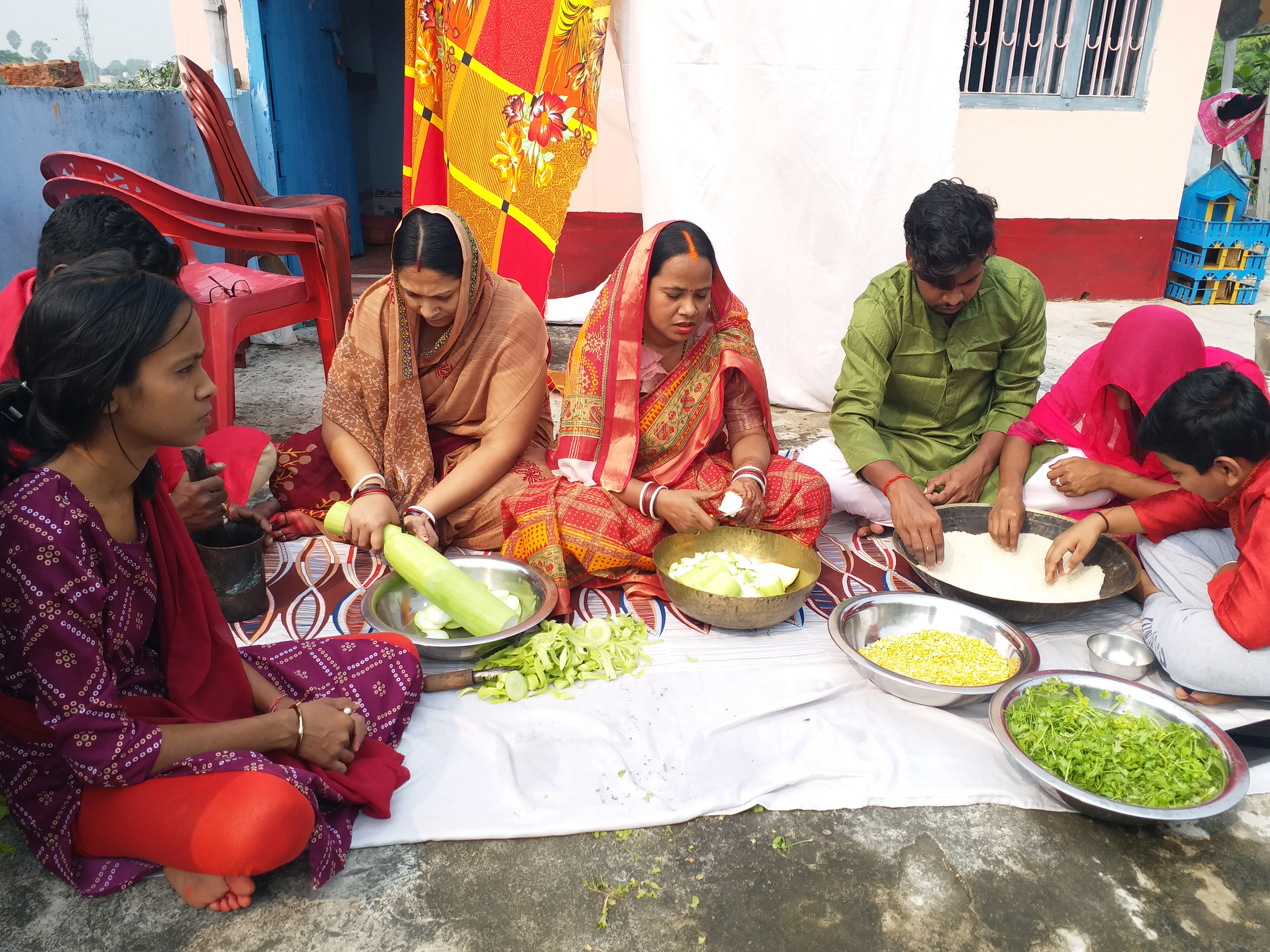 कदुआ भात बनाते छठ व्रती महिलाएं और परिवार के सदस्य