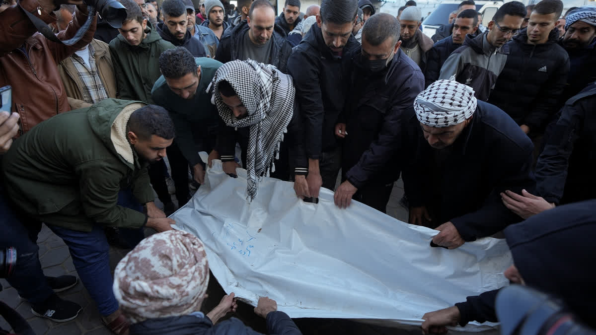 Palestinians carry the body of victim of an overnight Israeli strike, outside a hospital in Deir al-Balah, Gaza Strip, Wednesday, Dec. 4, 2024.