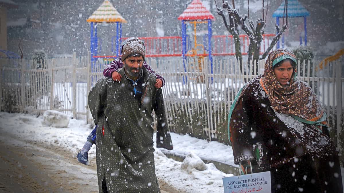 People walk amid fresh snowfall at Tangmarg area, in Baramulla district, Jammu and Kashmir, Sunday, Jan. 5, 2025. Fresh Snowfall Disrupts Life Across Kashmir