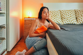 Women sitting at the side of her bed