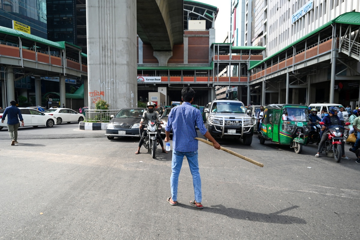 A Bangladeshi student controls the traffic as police went on strike in Dhaka on August 6, 2024.