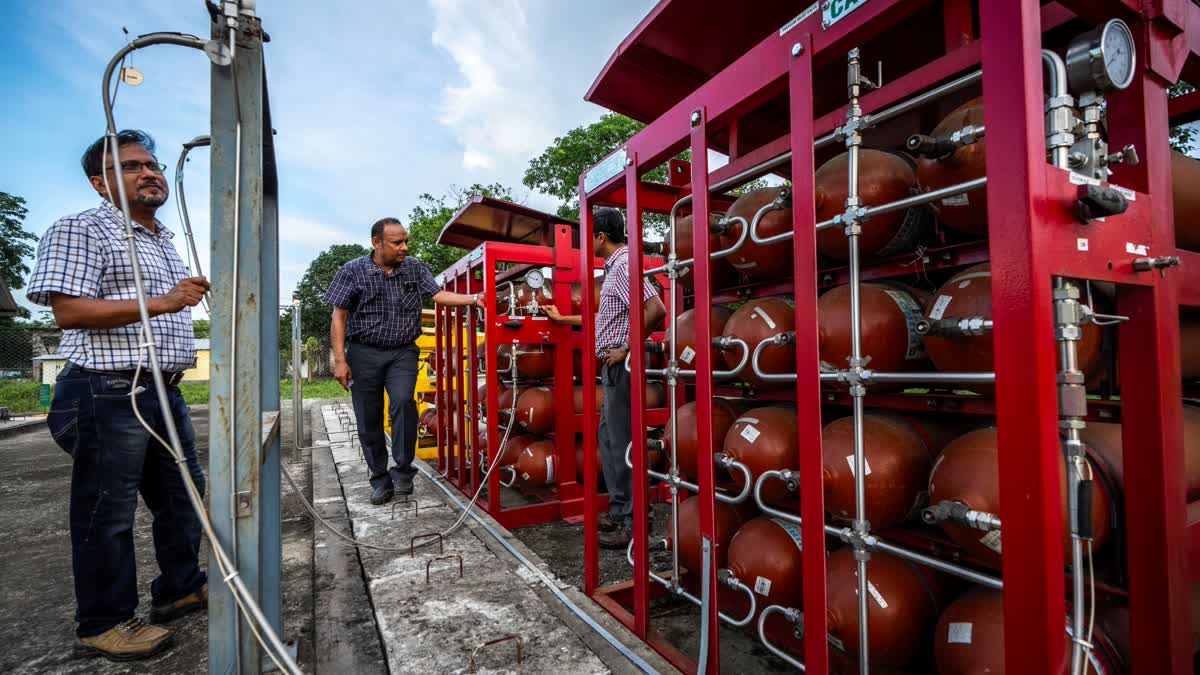 P V R Murthy, center, general manager at Oil India Limited, pump station 3, shows a part of a hydrogen plant in Jorhat, India, Thursday, Aug. 17, 2023. (AP)