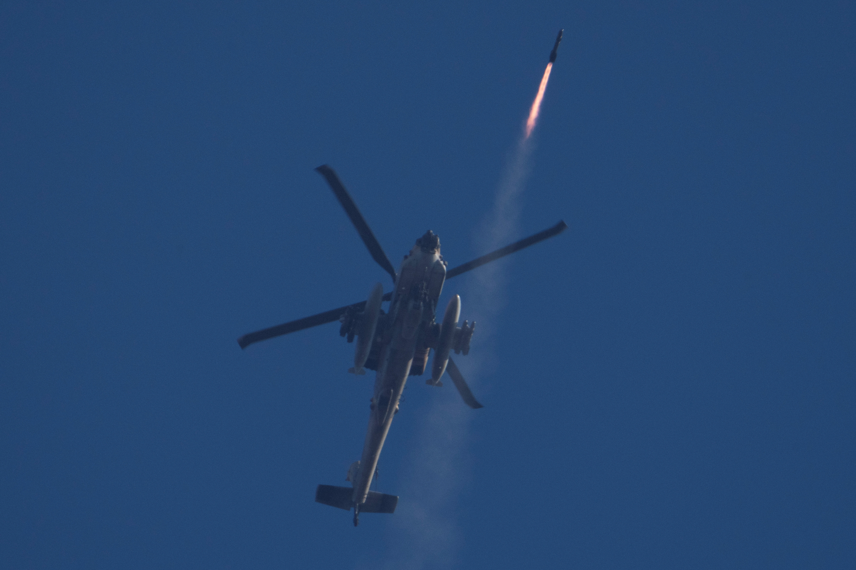 An Israeli Apache helicopter fires a missile towards southern Lebanon as seen from northern Israel, Friday, Oct. 4, 2024