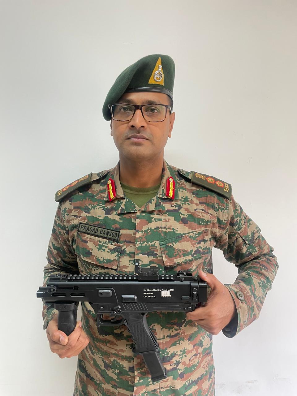 An Indian Army officer poses with the newly inducted Asmi pistol developed by Colonel Prasad Bansod of the Indian Army in collaboration with DRDO is being manufactured indigenously by Lokesh Machine Hyderabad.