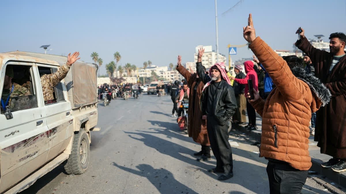 Residents cheer as Syrian anti government fighters pour into the captured central-west city of Hama on December 6, 2024.