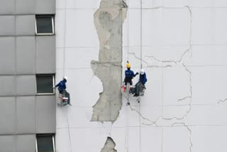 TOPSHOT - Workers repair damage on a high-rise commercial building in Bangkok on April 3, 2025, following the March 28 earthquake that struck central Myanmar and Thailand.