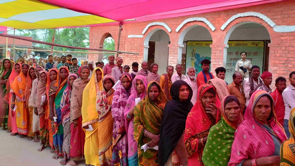 Women wait in a queue to cast vote in Bihar