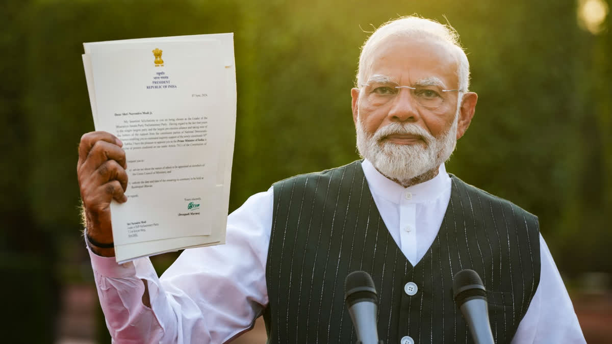 Prime Minister Narendra Modi shows to the media the letter of his appointment as Prime Minister by President Droupadi Murmu after he met her to formally stake claim for government formation, at Rashtrapati Bhavan, in New Delhi, Friday, June 7, 2024.