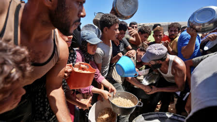 isplaced Palestinians gather for food distribution in Deir al Balah, central Gaza Strip, Aug. 23, 2024.